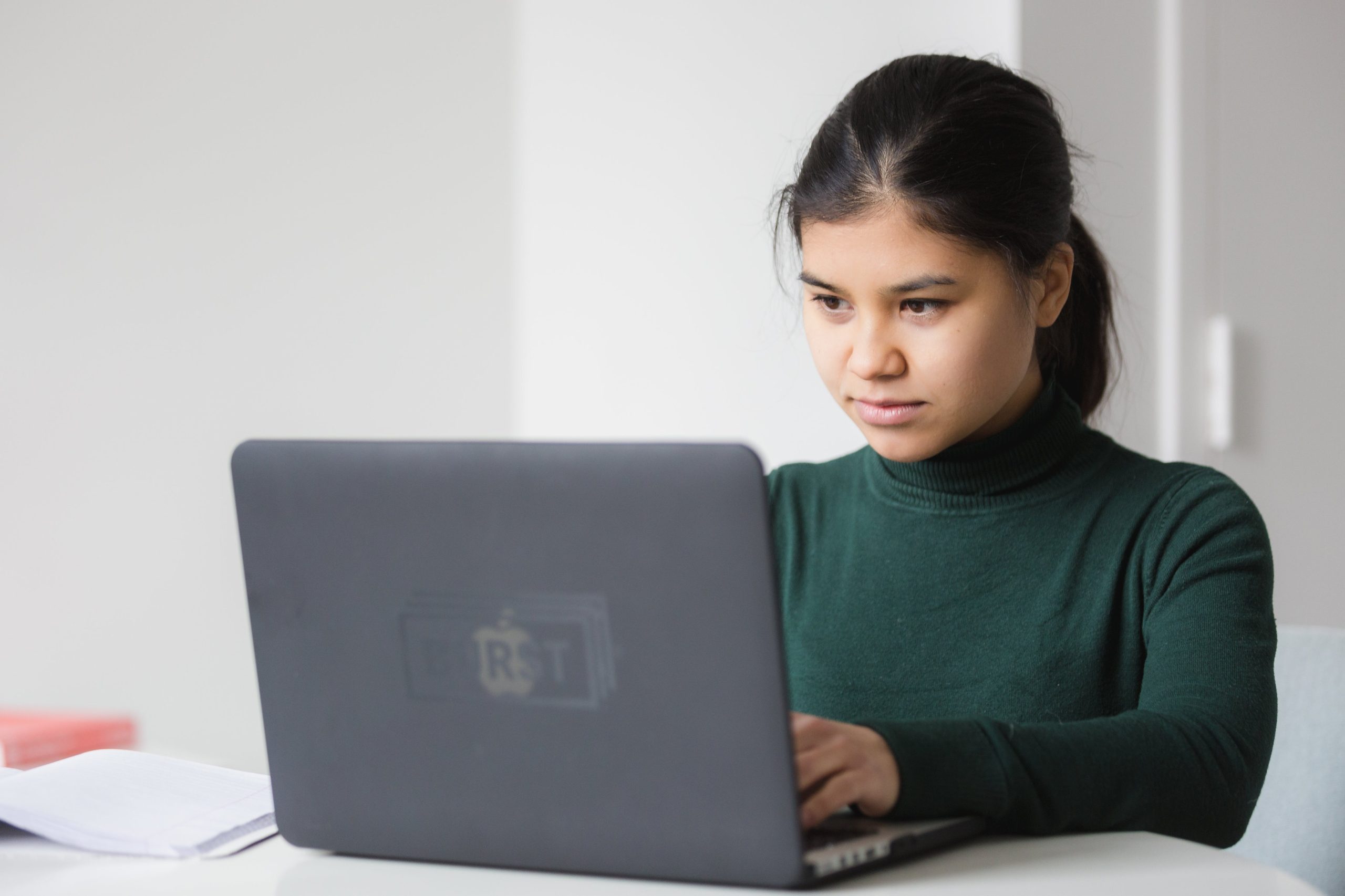 Nő elmélyülten dolgozik a laptopja előtt